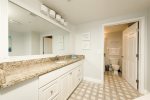 Primary bathroom with walk in shower, granite counters and high end tile floors